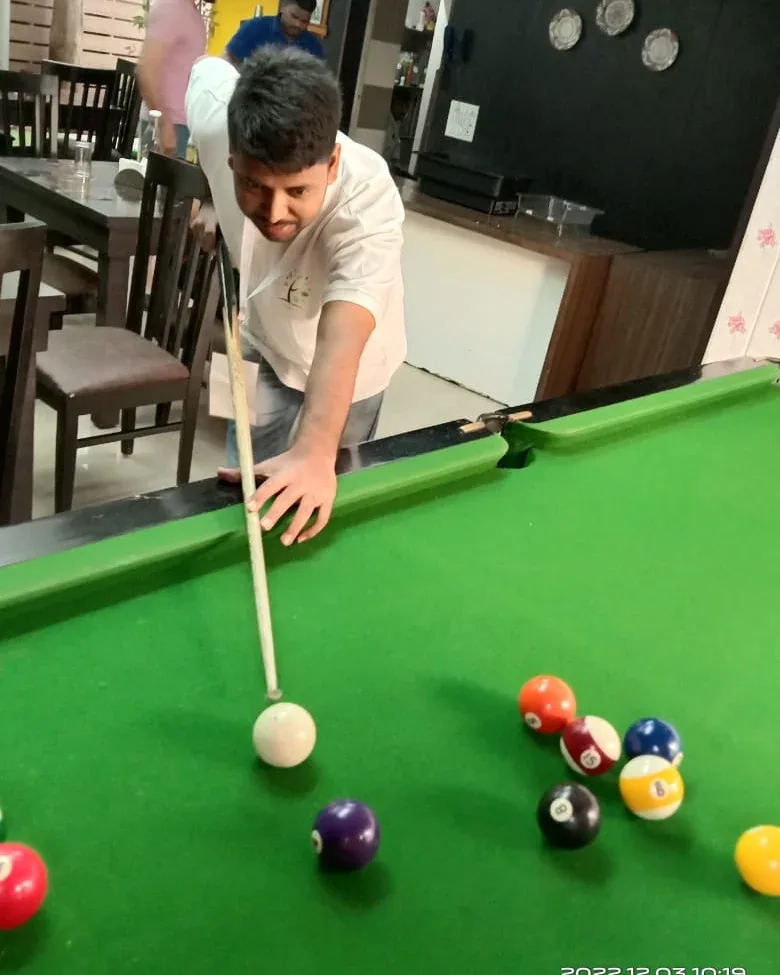 Shanu Quraishi lining up a shot at the pool table